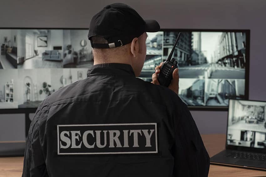 Security guard overseeing CCTV surveillance in a modern security control room.