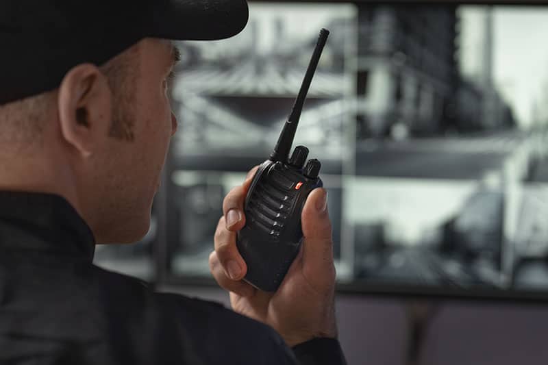 Security guard using radio communication for surveillance and security at a facility.